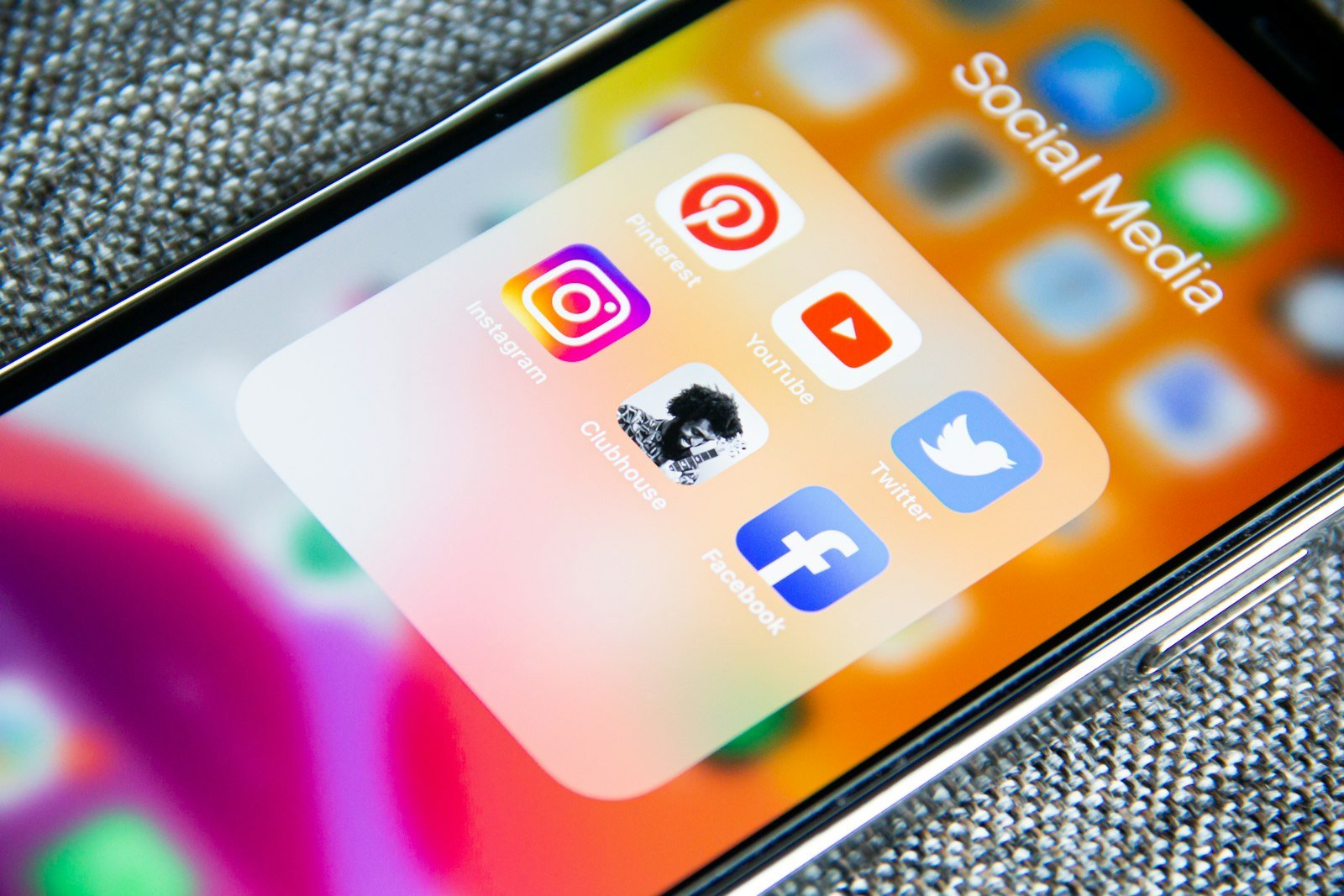 Phone screen showing a folder of social media apps, representing content repurposed across platforms