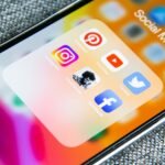 Smartphone screen showing a Social Media folder of app icons including Instagram, Facebook and YouTube