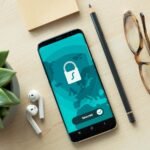 Smartphone showing a Secured padlock screen on a desk, representing website security for small business