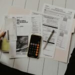 Calculator and finance paperwork representing a car dealership finance repayment estimate