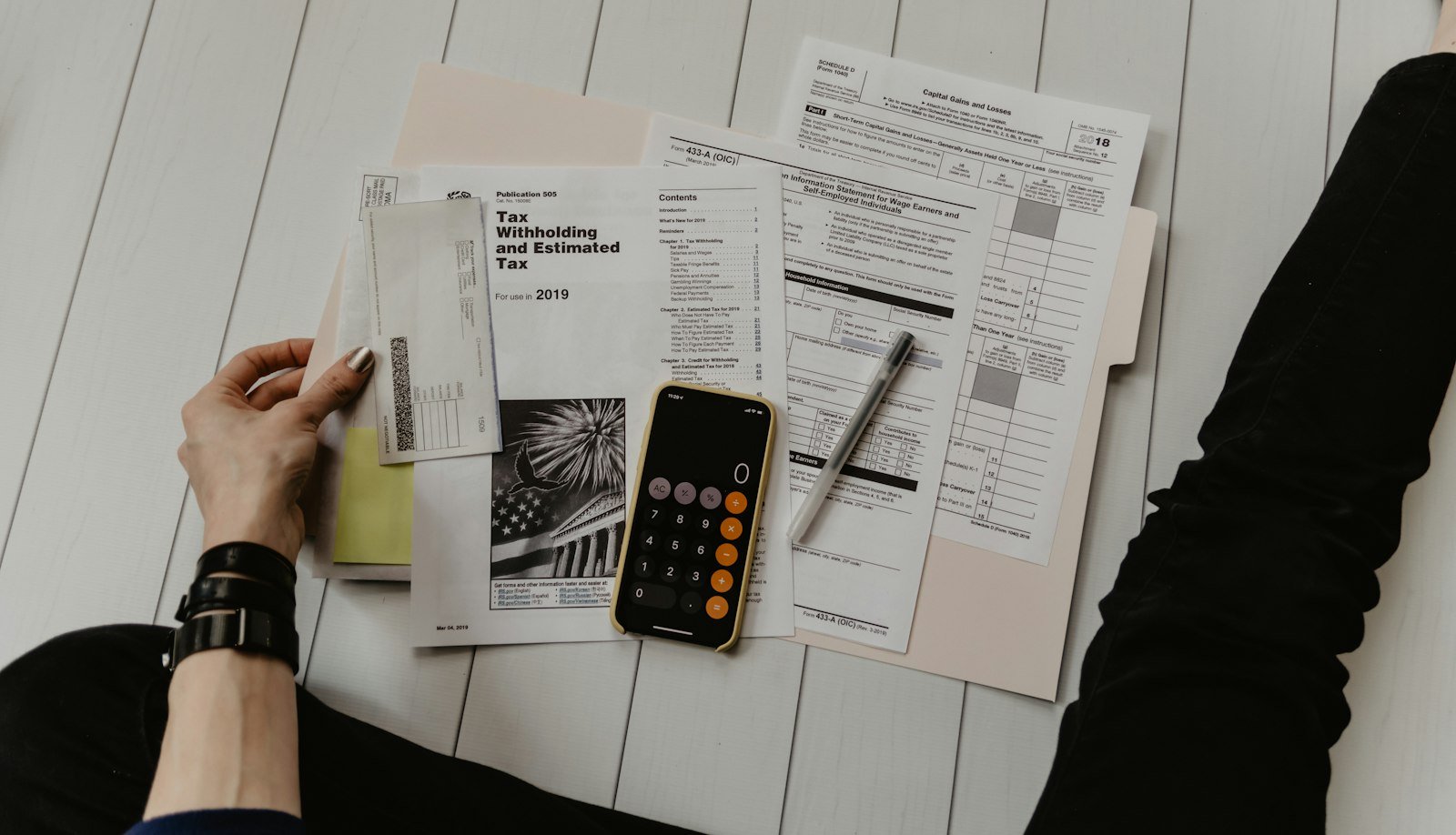 Calculator and finance paperwork representing a car dealership finance repayment estimate