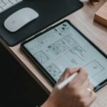 Designer sketching a small business homepage wireframe on a tablet