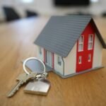 Miniature house model with keys on a table, representing a real estate agent website Auckland buyers and sellers can trust