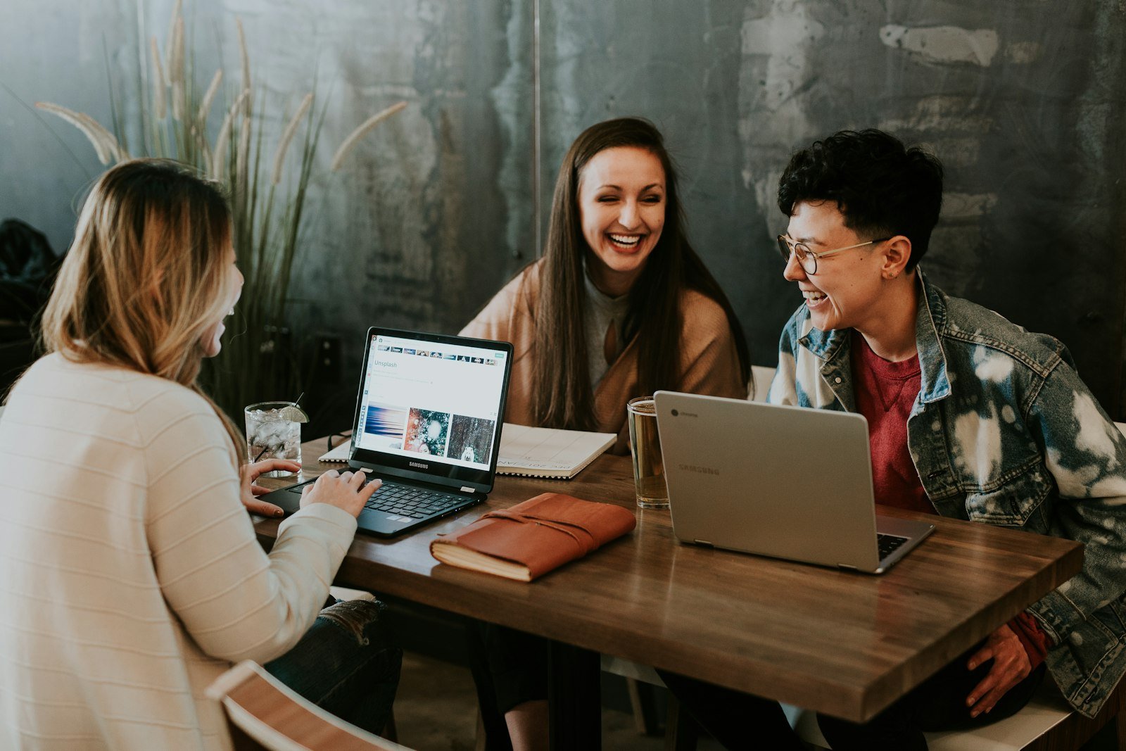 Small business team planning website content together on laptops at a table