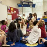 Teacher and young children sitting together on a classroom mat during group learning time