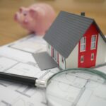 Mortgage Adviser Website Design Auckland: Disclosure, Trust and Leads 2 Toy house model with blueprint, pen and magnifying glass representing mortgage and home loan planning