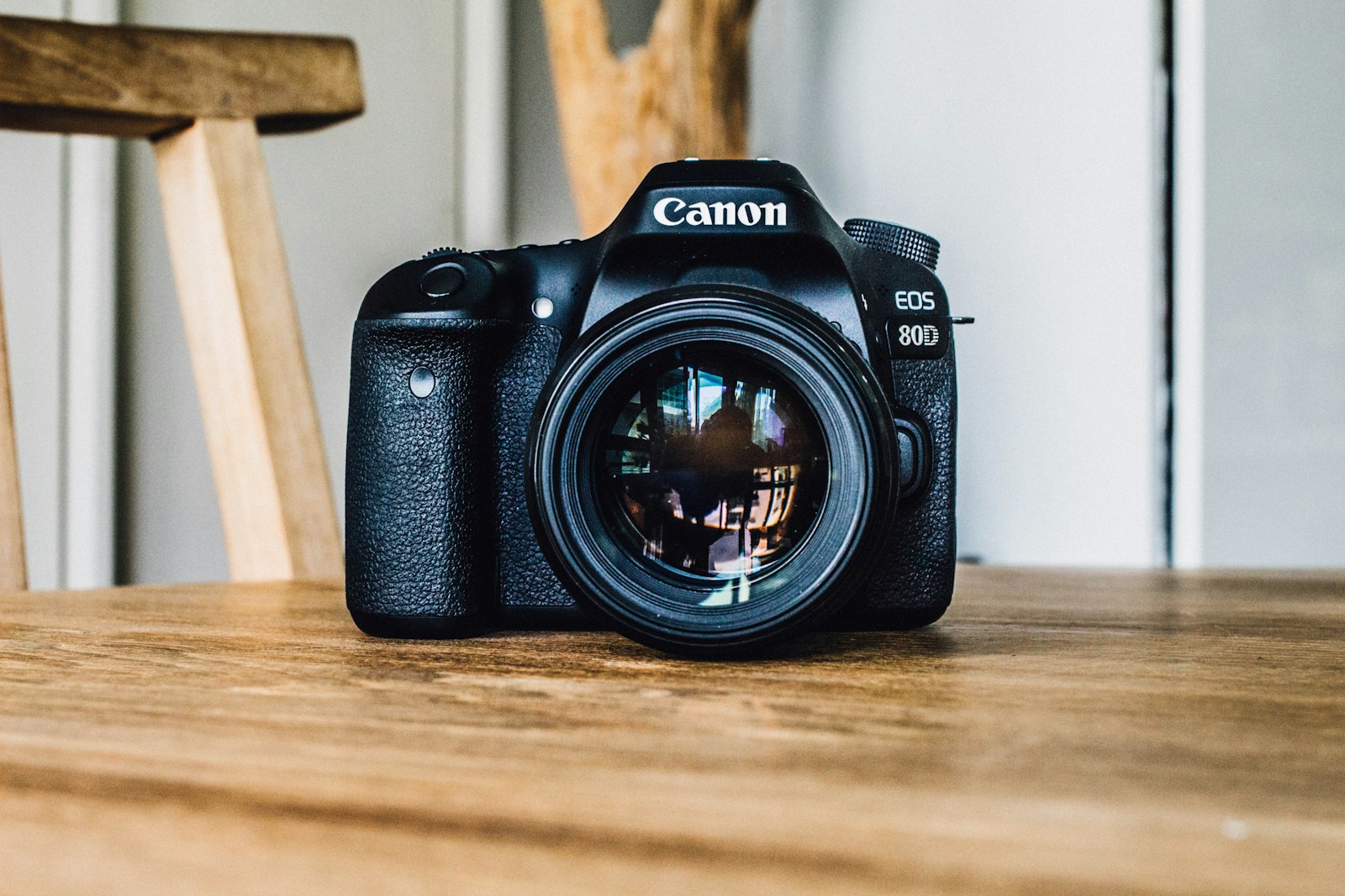 DSLR camera on a wooden desk, representing the choice between real and stock photography for a small business website