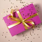 Pink gift box with gold ribbon and confetti, representing a social media giveaway prize